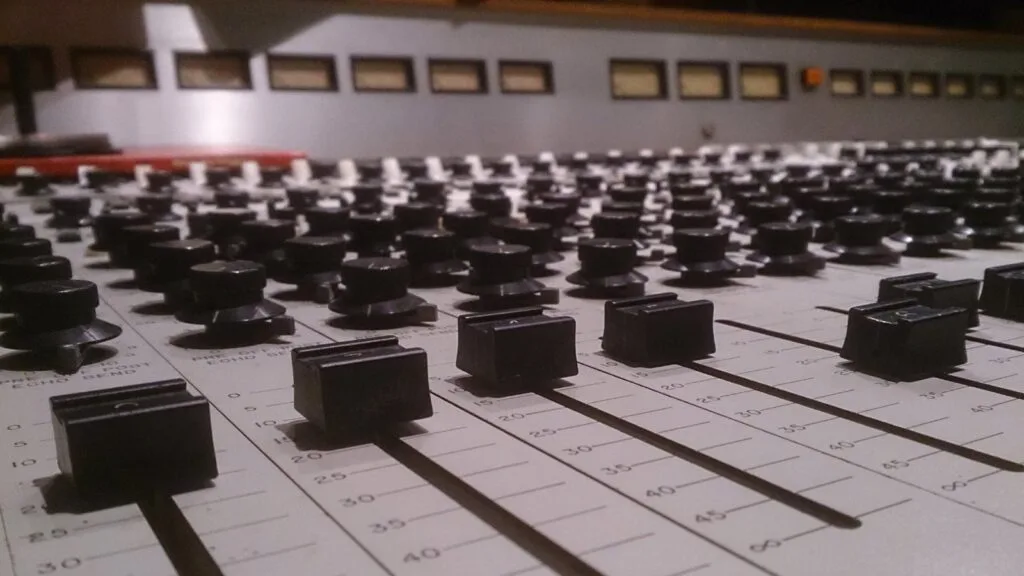 Audio mixing console faders in recording studio