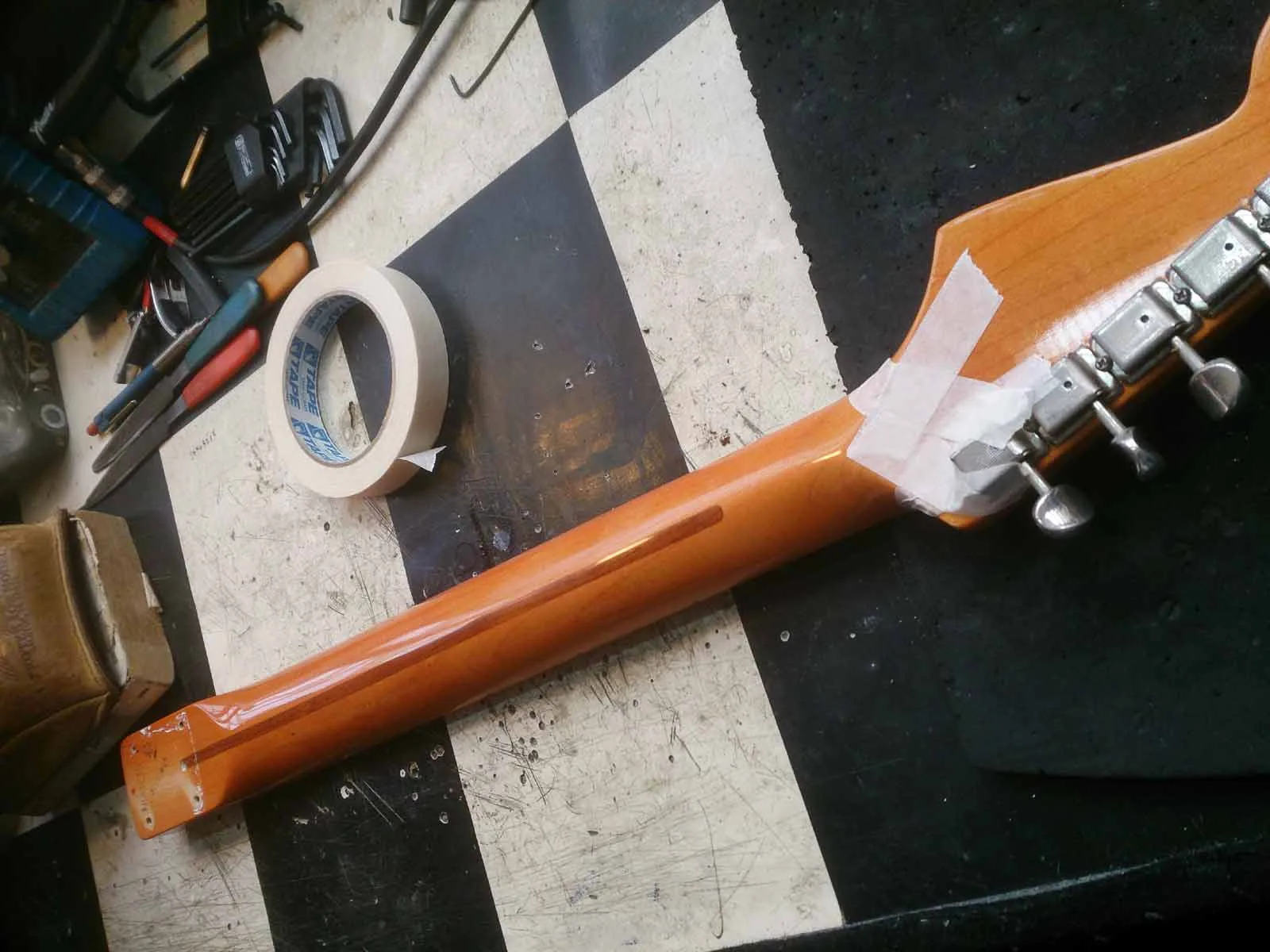 Masking tape applied to the guitar neck before sanding